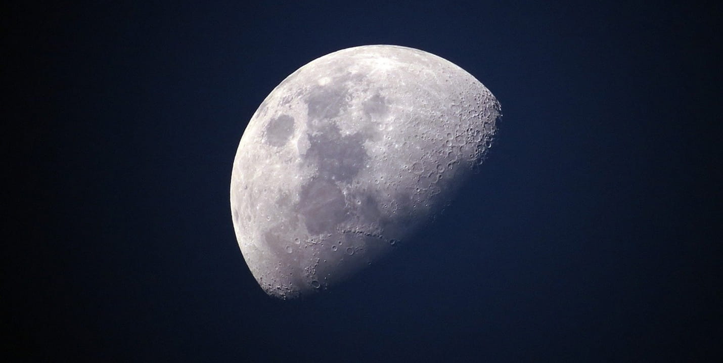 Nahaufnahme des Mondes mit deutlich sichtbaren Kratern vor dunkelblauem Himmel
