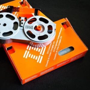 Alte IBM-Magnetbandspule liegt auf einer orangefarbenen Verpackung