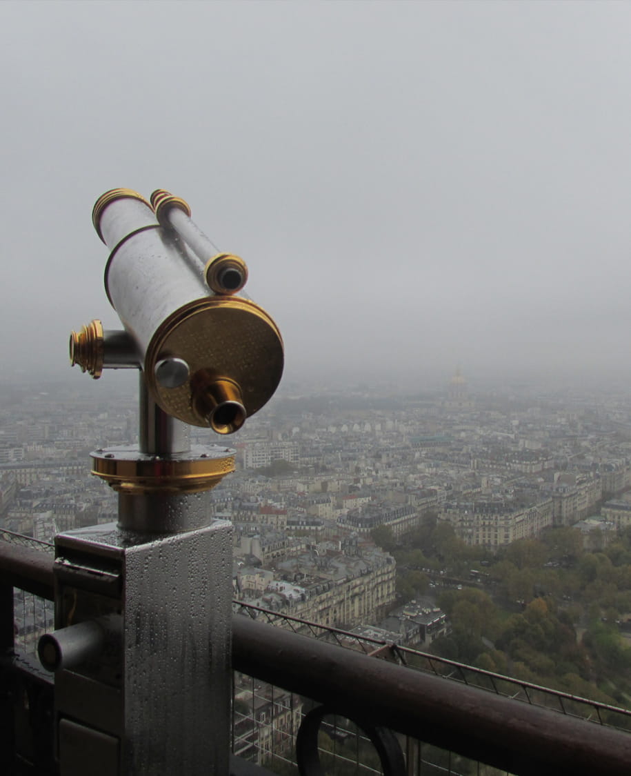 Aussichtsfernrohr über einer Stadt im Nebel als Symbol für Sichtbarkeit, Suchmaschinen, klare Regeln und strategisches Webdesign