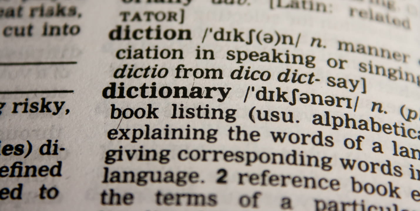 Nahaufnahme einer englischen Wörterbuchseite mit dem hervorgehobenen Begriff „dictionary“